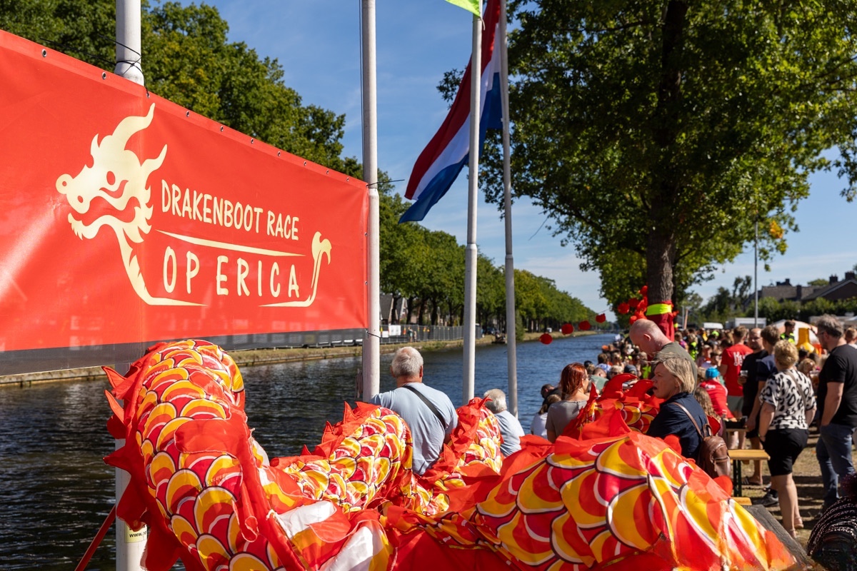 Drakenboot Race op Erica banner met drakenkoppen langs de Verlengde Vaart